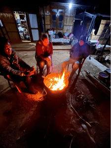 Warming up at night by the fire in anticipation of a warm bowl of thukpa
